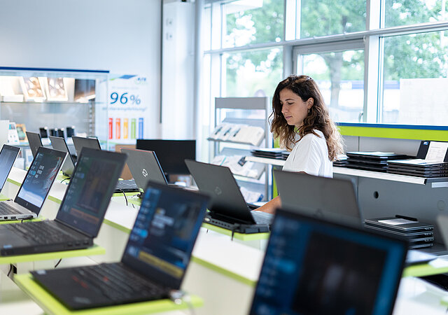 AfB Shop / ausgestellte Laptops zum Verkauf / Person interessiert auf die Rechner blickend