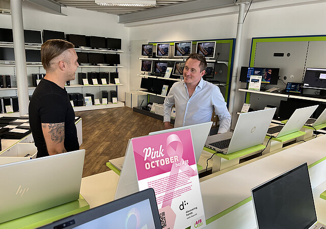 Zwei Personen in einem Shop mit Hardware und Aufsteller in Pink