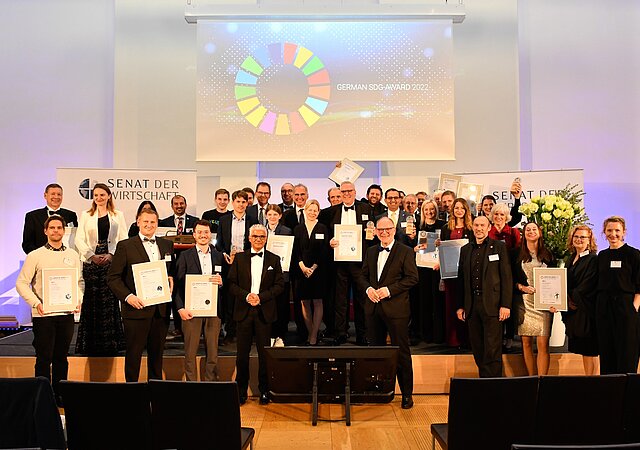 Gruppenbild / SDG Auszeichnung 2022 / alle Gewinner / Senat der Wirtschaft Plakativ im Hintergrund