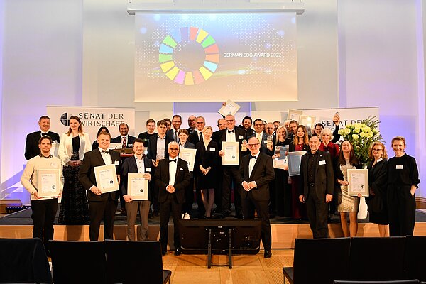 Gruppenbild / SDG Auszeichnung 2022 / alle Gewinner / Senat der Wirtschaft Plakativ im Hintergrund