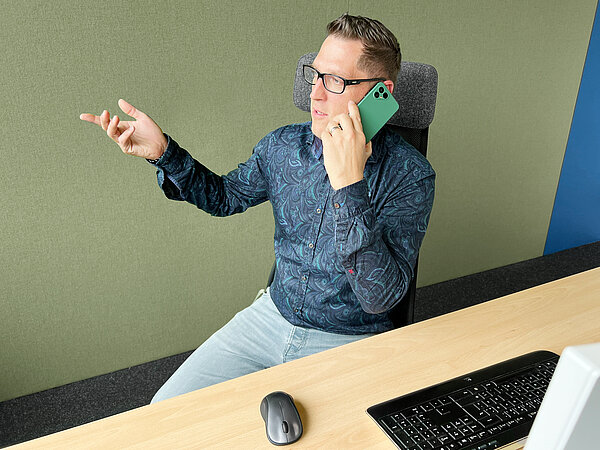 Dominik Gomer, Head of E-Commerce bei AfB social & green IT, telefoniert mit dem Fairphone 4.