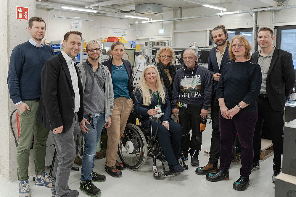 Gruppenfoto in der Datenlöschung: die fünf Bundestagsabgeordneten und 5 Personen von AfB, eine Person sitzt im Rollstuhl.