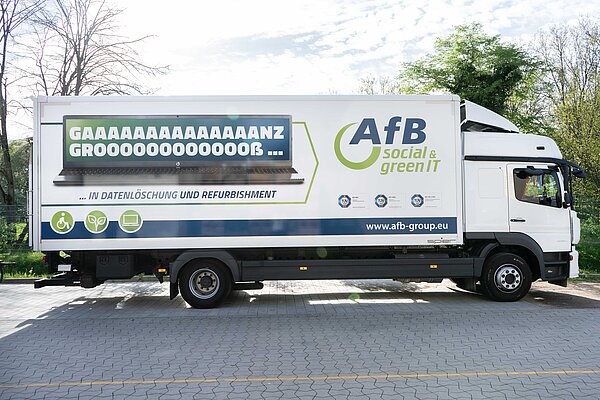 Seitenansicht eines weißen LKWs mit AfB-Logo und der Aufschrift "Ganz groß in Datenlöschung und Refurbishment".