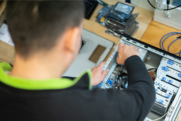 An AfB IT technician repairs a PC for reuse.
